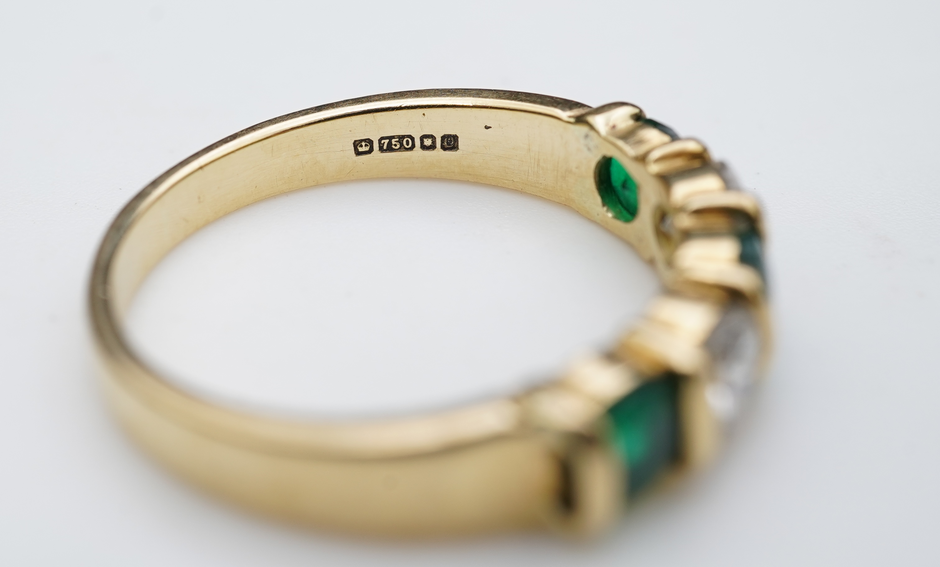 An emerald and diamond five-stone ring